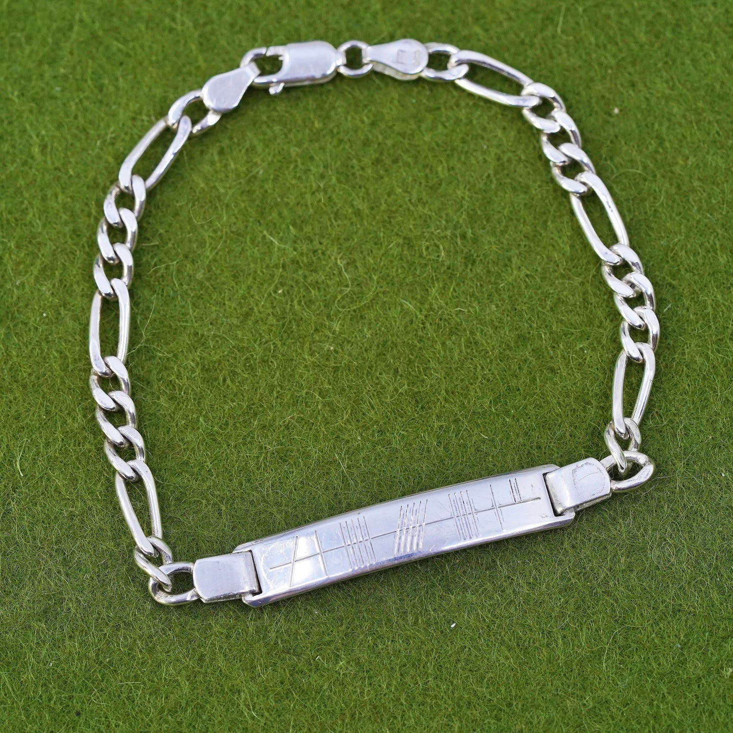 7.25” sterling silver bracelet, 925 figaro chain with line engraved bar tag