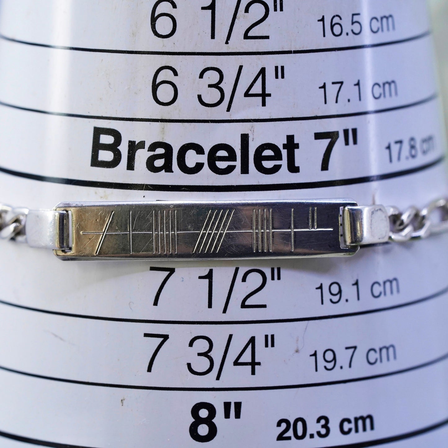7.25” sterling silver bracelet, 925 figaro chain with line engraved bar tag