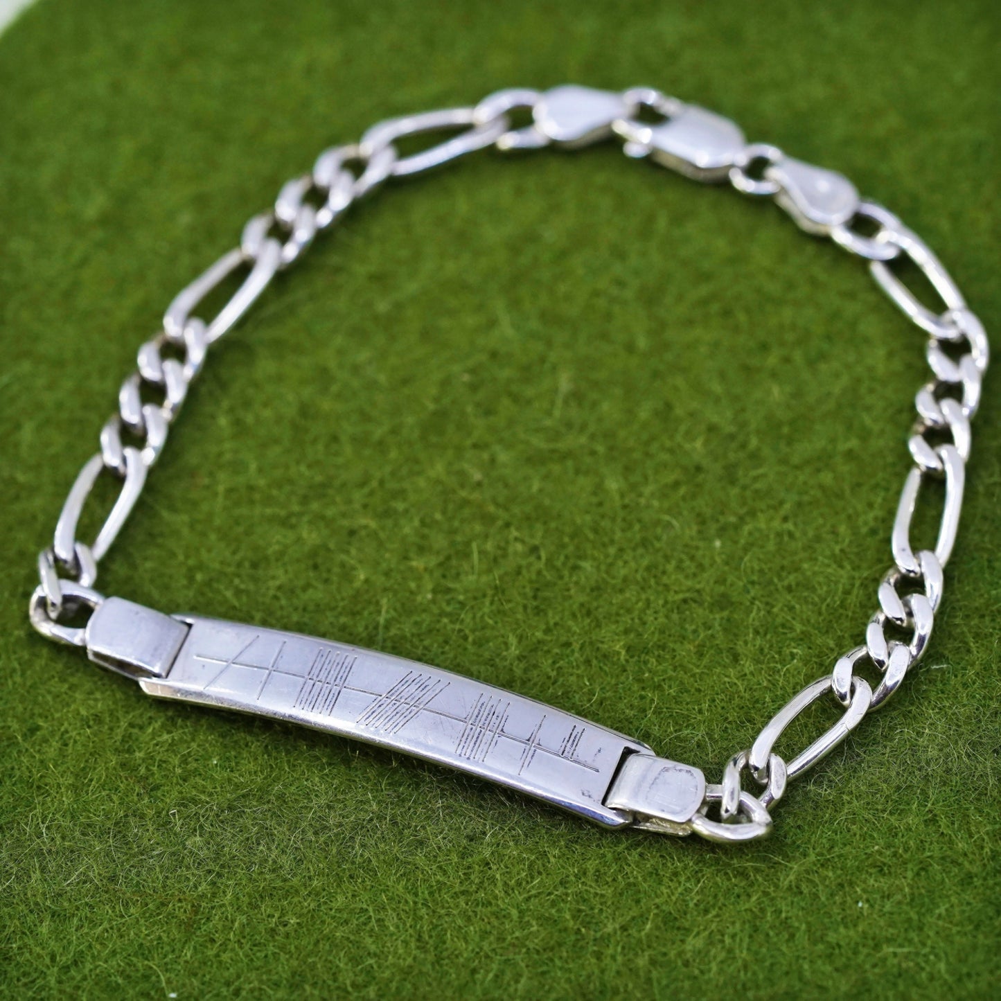 7.25” sterling silver bracelet, 925 figaro chain with line engraved bar tag