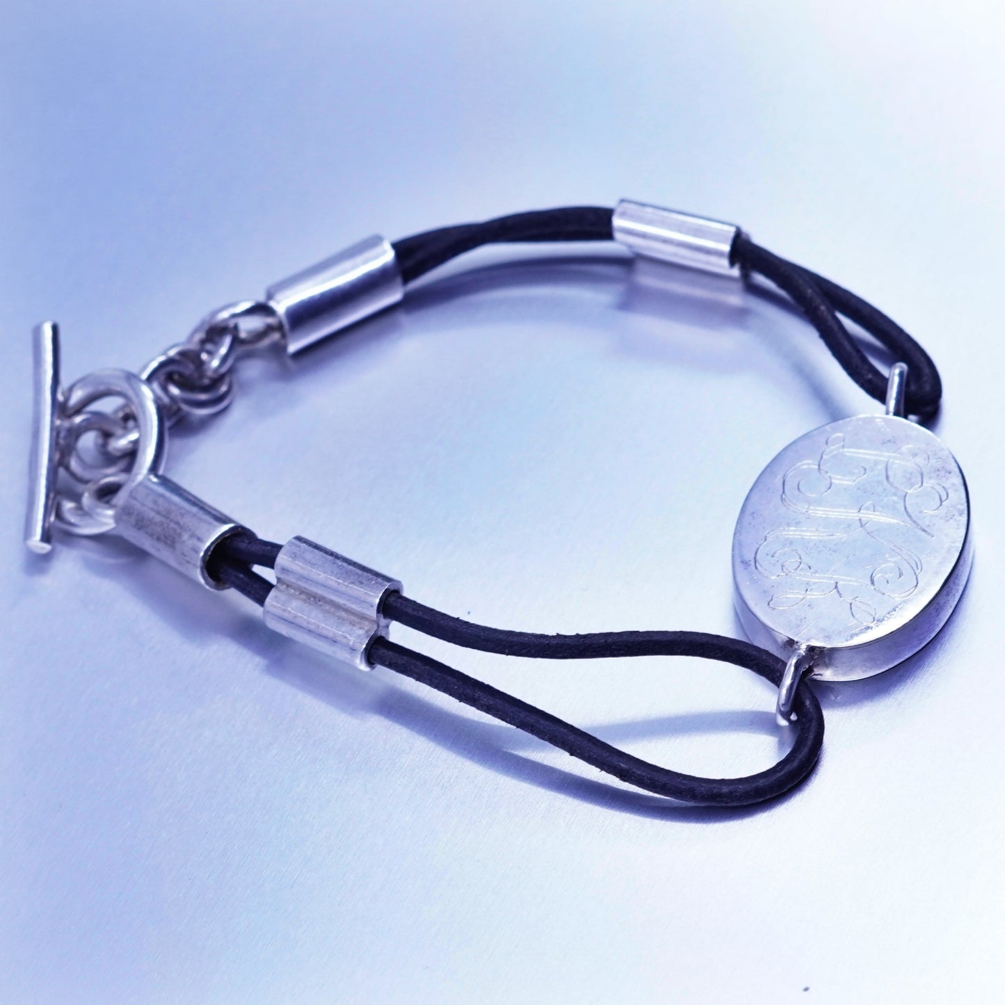 6.75”, sterling 925 silver handmade monogram “LKK” bracelet black leather core