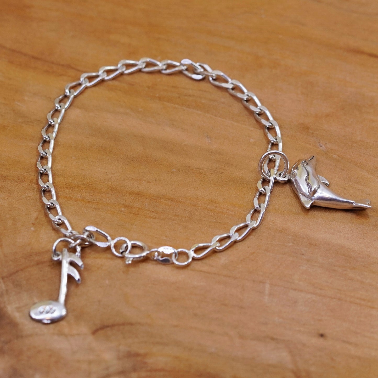 6.75”, Sterling silver bracelet, 925 curb chain with dolphin music note charms